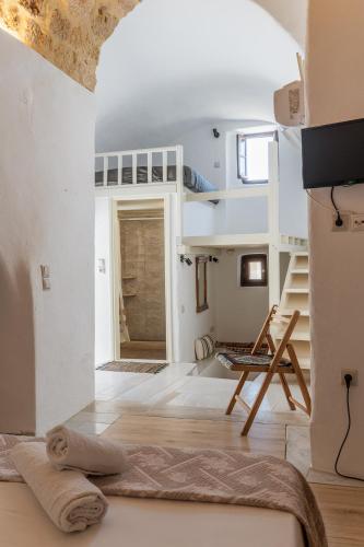 a room with a bed and stairs in a house at Goulas Traditional Guesthouse in Monemvasia