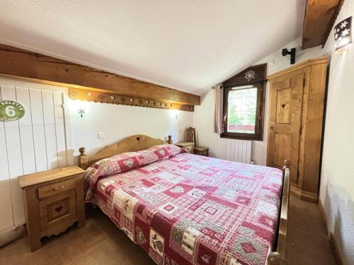 une chambre avec un lit avec une couette rouge dans l'établissement Les Chalets Des Evettes - Appartement de charme au pied des pistes, dans une résidence avec piscine MAE-2864, à Notre-Dame-de-Bellecombe