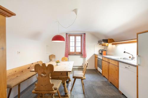 a kitchen with a table and chairs in a room at Chesa Michel in Bever