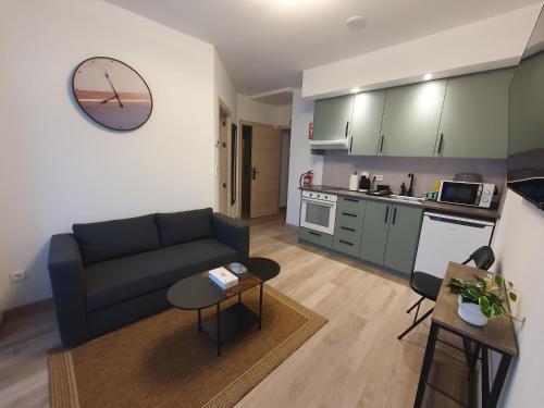 a living room with a couch and a kitchen at Sella Rooms in Arriondas