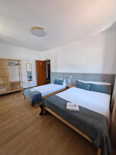 two beds in a large room with wooden floors at Old Village Hostel in Ponte de Lima