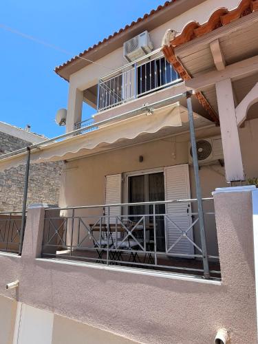 a balcony of a house with a table on it at Bloom Garden Apartment in Methoni