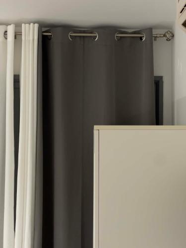 a black shower curtain next to a white cabinet at Casa Maria-Anneta in Kalyves Poligirou