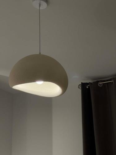 a light fixture hanging from a ceiling with a curtain at Casa Maria-Anneta in Kalyves Poligirou