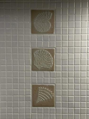 a white tiled wall with four brown tiles at Casa Maria-Anneta in Kalyves Poligirou