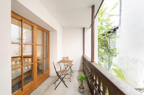 a balcony with a table and chairs and a window at Chesa Michel in Bever