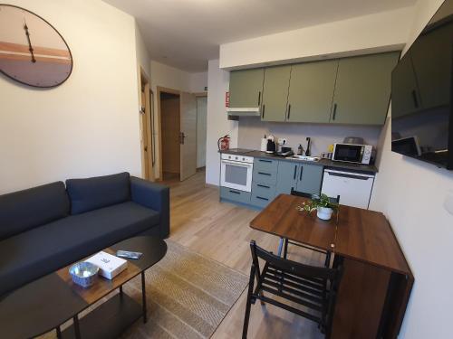 a living room with a blue couch and a table at Sella Rooms in Arriondas