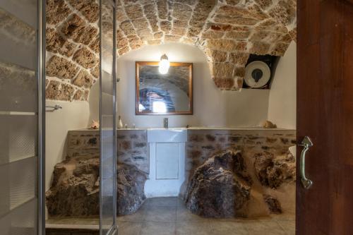 a bathroom with a shower with a glass door at Goulas Traditional Guesthouse in Monemvasia