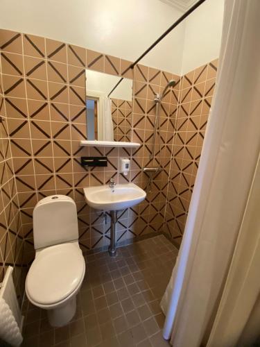 a bathroom with a toilet and a sink at Ljusterö Logi in Norra Ljustero