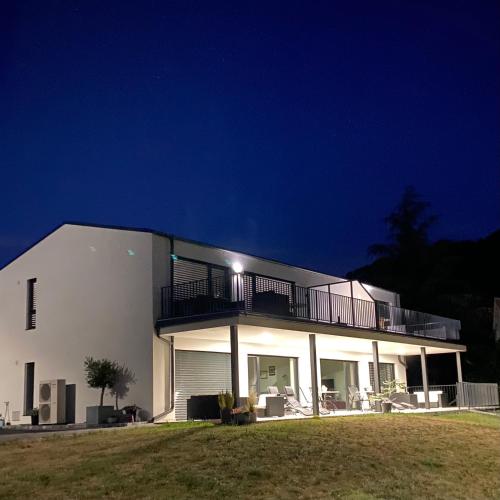 a large white house with a balcony at night at Peter`s Lucky Home Balaton, Vonyarcvashegy in Vonyarcvashegy