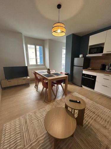 een woonkamer met een tafel en een keuken bij Côté Pyrénées - Lourdes in Lourdes