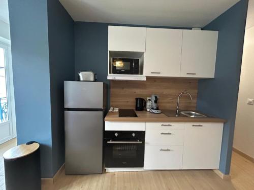 een keuken met een koelkast en een magnetron bij Côté Pyrénées - Lourdes in Lourdes