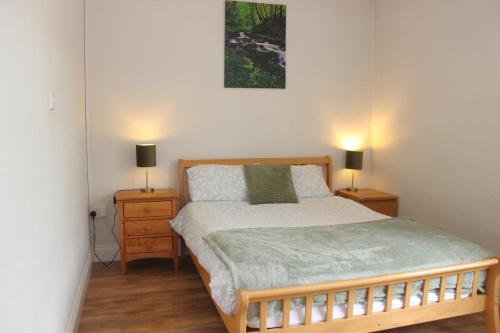a bedroom with a bed with two lamps on two night stands at Family Home, 20 mins from Youghal Beach in Killeagh