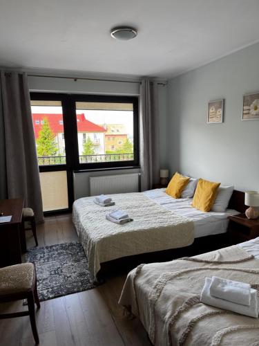 a hotel room with two beds and a window at Willa Klif &Spa in Jastrzębia Góra