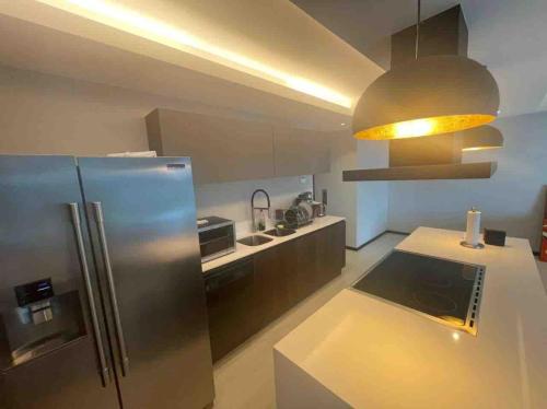 a kitchen with a stainless steel refrigerator and a sink at Modern and spacious apartment in Narval, Bucerías in Cedro