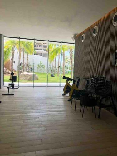 a room with a large glass wall with tables and chairs at Modern and spacious apartment in Narval, Bucerías in Cedro