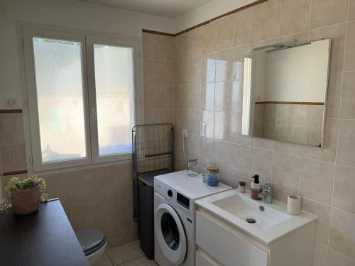 a bathroom with a washing machine and a sink at Le Cocon de Beynat - 1 Chambre in Beynat