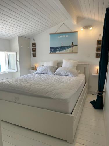 - une chambre blanche avec un grand lit blanc dans l'établissement La Villa Delphine, à Vaux-sur-Mer