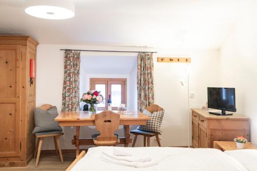 a bedroom with a table and chairs and a television at Chesa Michel in Bever