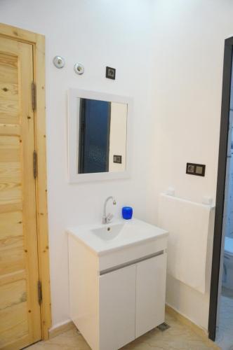 a bathroom with a white sink and a mirror at 2 Voies Résidence in Dakhla