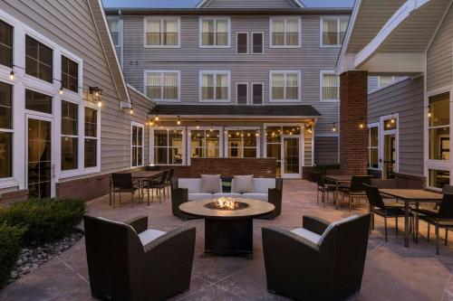 an outdoor patio with chairs and tables and a fire pit at Residence Inn by Marriott Albany Washington Avenue in Albany