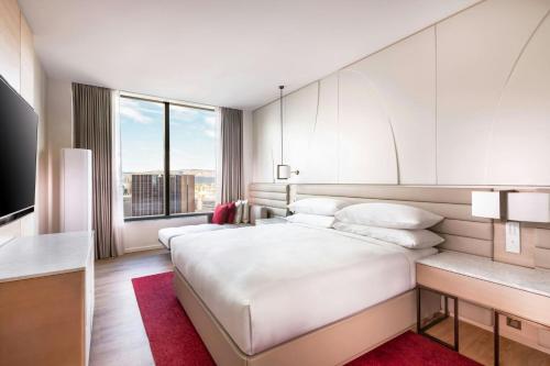 a bedroom with a large white bed and a large window at Adelaide Marriott Hotel in Adelaide
