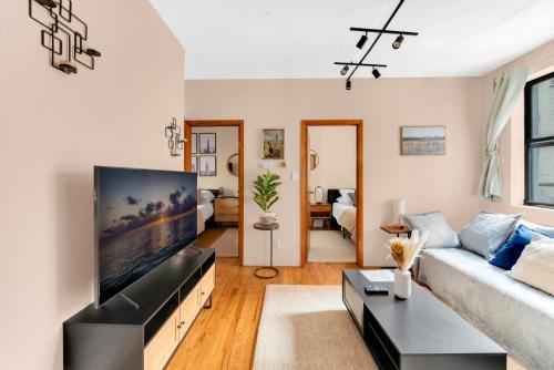 a living room with a large flat screen tv at Stylish 2 Bedroom Apartment in Chelsea in New York