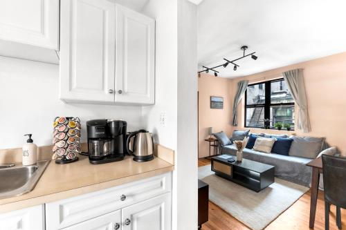 a kitchen and a living room with a couch at Stylish 2 Bedroom Apartment in Chelsea in New York
