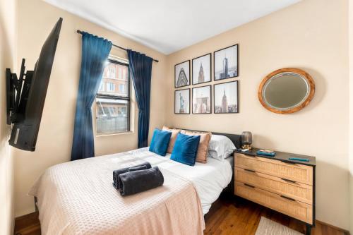 a bedroom with a bed and a dresser and a mirror at Stylish 2 Bedroom Apartment in Chelsea in New York