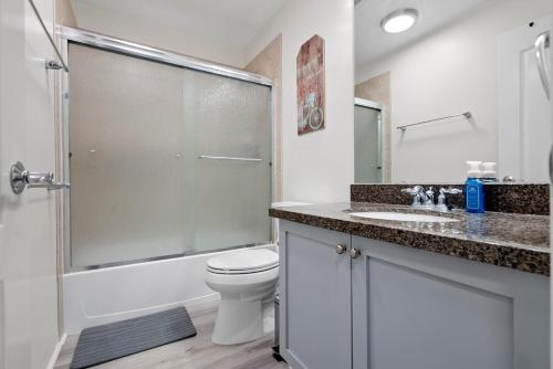 a bathroom with a shower and a toilet and a sink at Relaxing Paradise Getaway in Kapolei