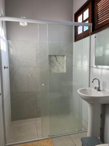 une douche en verre dans une salle de bain avec un lavabo dans l'établissement Apto ao lado da Praça da Sé, ótima localização, à Crato