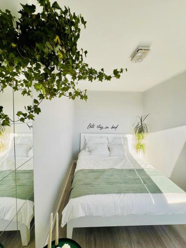 a bedroom with a white bed and a potted plant at Apartament Panorama Żory in Żory