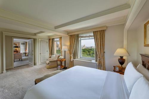 a bedroom with a large bed and a large window at The Ritz-Carlton New York, Central Park in New York