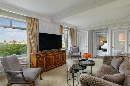 a living room with a couch and a television at The Ritz-Carlton New York, Central Park in New York