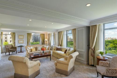 a living room with couches and chairs and windows at The Ritz-Carlton New York, Central Park in New York
