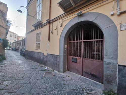 un bâtiment avec une porte rouge dans une rue dans l'établissement Aurora's house Materdei, à Naples