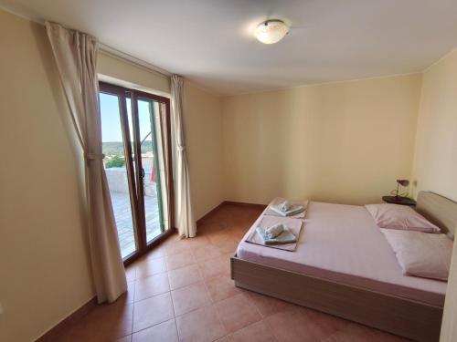 een slaapkamer met een bed en een groot raam bij Villa Mirta in Široke