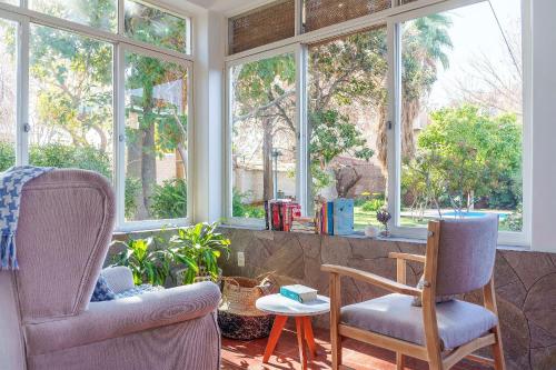 ein Raum mit zwei Stühlen und einem Tisch und Fenstern in der Unterkunft Buen Viaje Mendoza in Mendoza