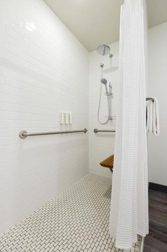 a white shower with a shower curtain in a bathroom at Archer Hotel Boston/Burlington in Burlington