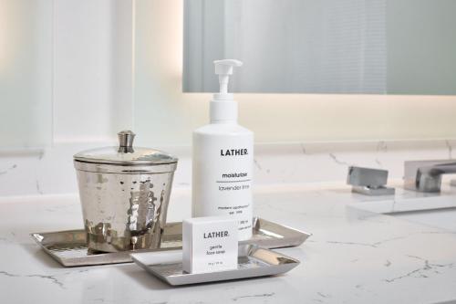 a bathroom counter with a bottle of lotion and a blender at Archer Hotel Boston/Burlington in Burlington