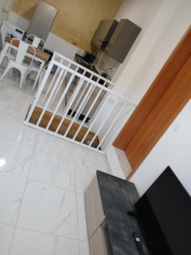 a staircase in a living room with white tile floors at Maron 32 in Cospicua
