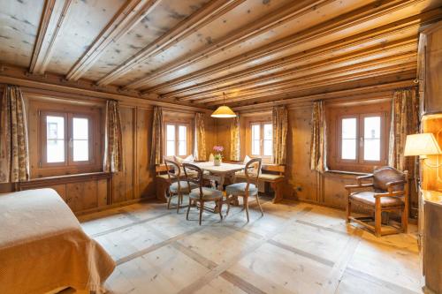 a room with a table and chairs and windows at Chesa Michel in Bever
