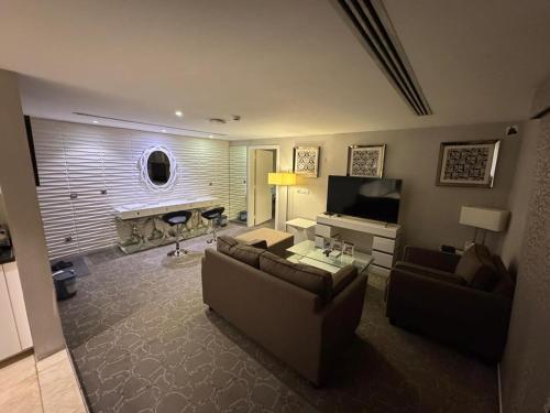 a living room with two couches and a television at SIXTY THREE HOTEL SUiTES in Riyadh