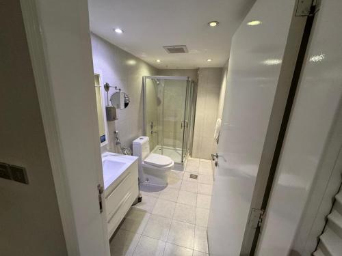 a bathroom with a shower and a toilet and a sink at SIXTY THREE HOTEL SUiTES in Riyadh