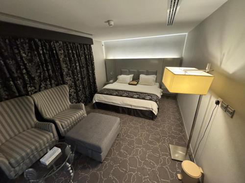 a hotel room with a bed and a couch and a chair at SIXTY THREE HOTEL SUiTES in Riyadh