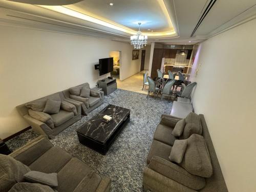 a living room with couches and a television and a living room at SIXTY THREE HOTEL SUiTES in Riyadh