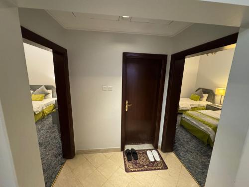 a room with two beds and a door with a mirror at SIXTY THREE HOTEL SUiTES in Riyadh
