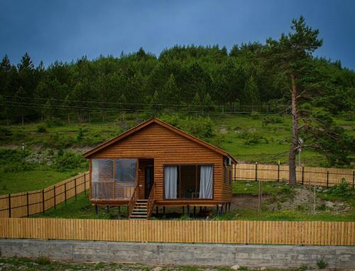 a small wooden cabin with a fence around it at Velevuka - Cottage in Racha in Ambrolauri