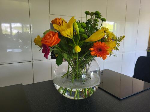 a glass vase filled with flowers on a table at Shalom, in Saundersfoot, near the sea in Saundersfoot