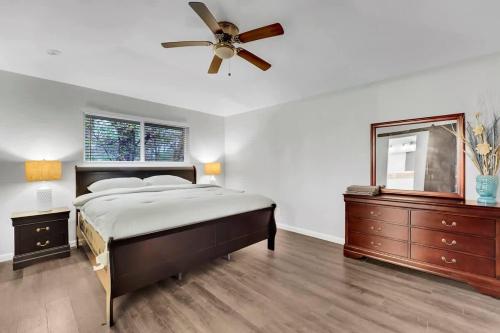 a bedroom with a bed and a ceiling fan at Serene Deck 10 Mins Garland City Square in Garland